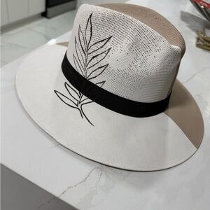 It’s a hand painted Stylish White and Tan Hat with Black Leaf Design